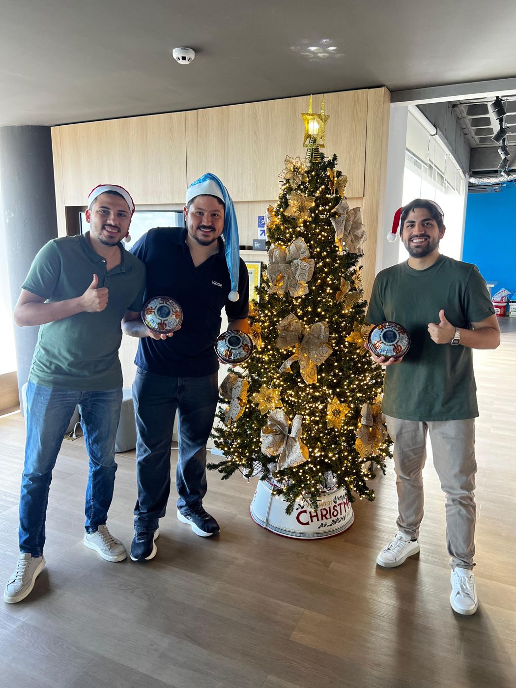 Time da Praso de gorro ao lado da árvore de Natal