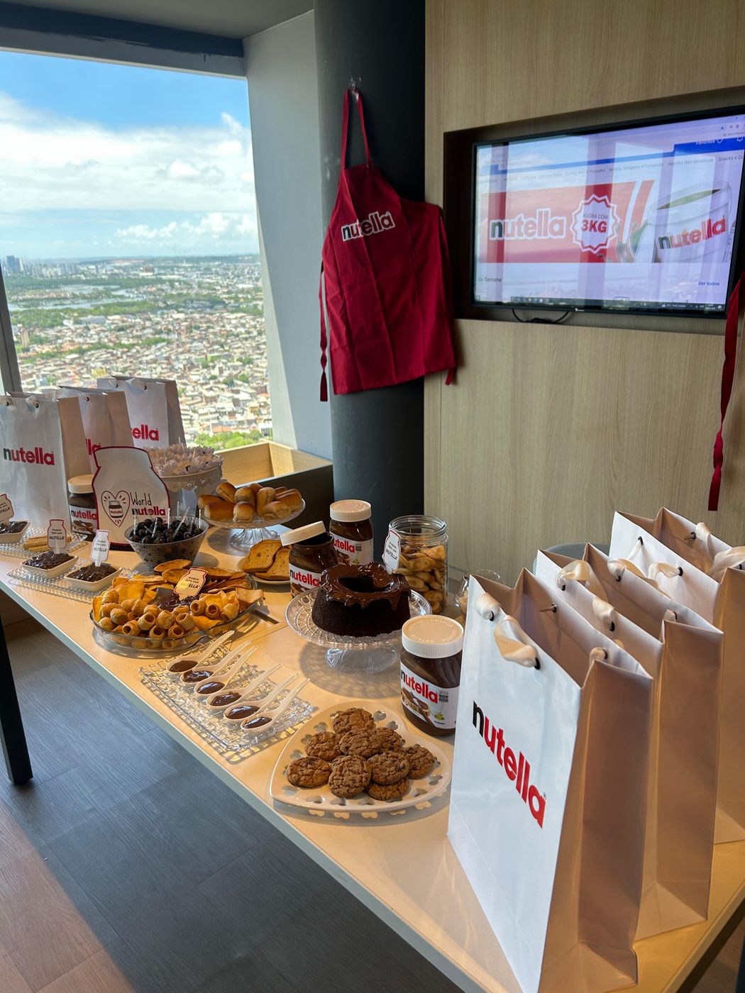 Mesa de doces e sacolas Nutella com a vista de Recife